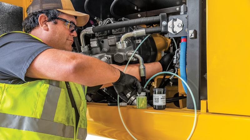 Técnico tomando una muestra de aceite de un equipo John Deere para su análisis